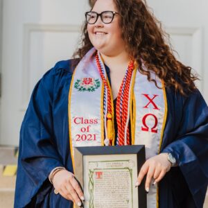 woman in blue and white academic dress holding certificate